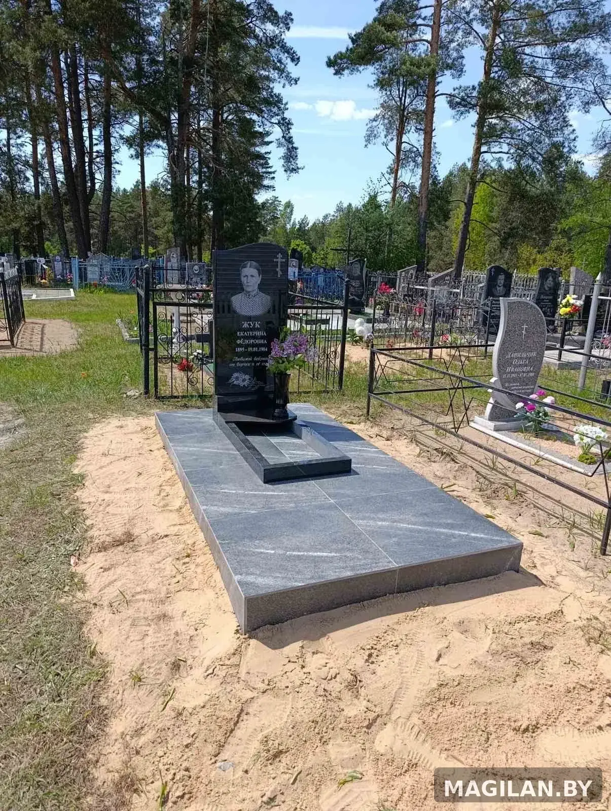 Одиночный памятник с цветником и керамогранитной облицовкой площадки в деревне Углата Брестской области