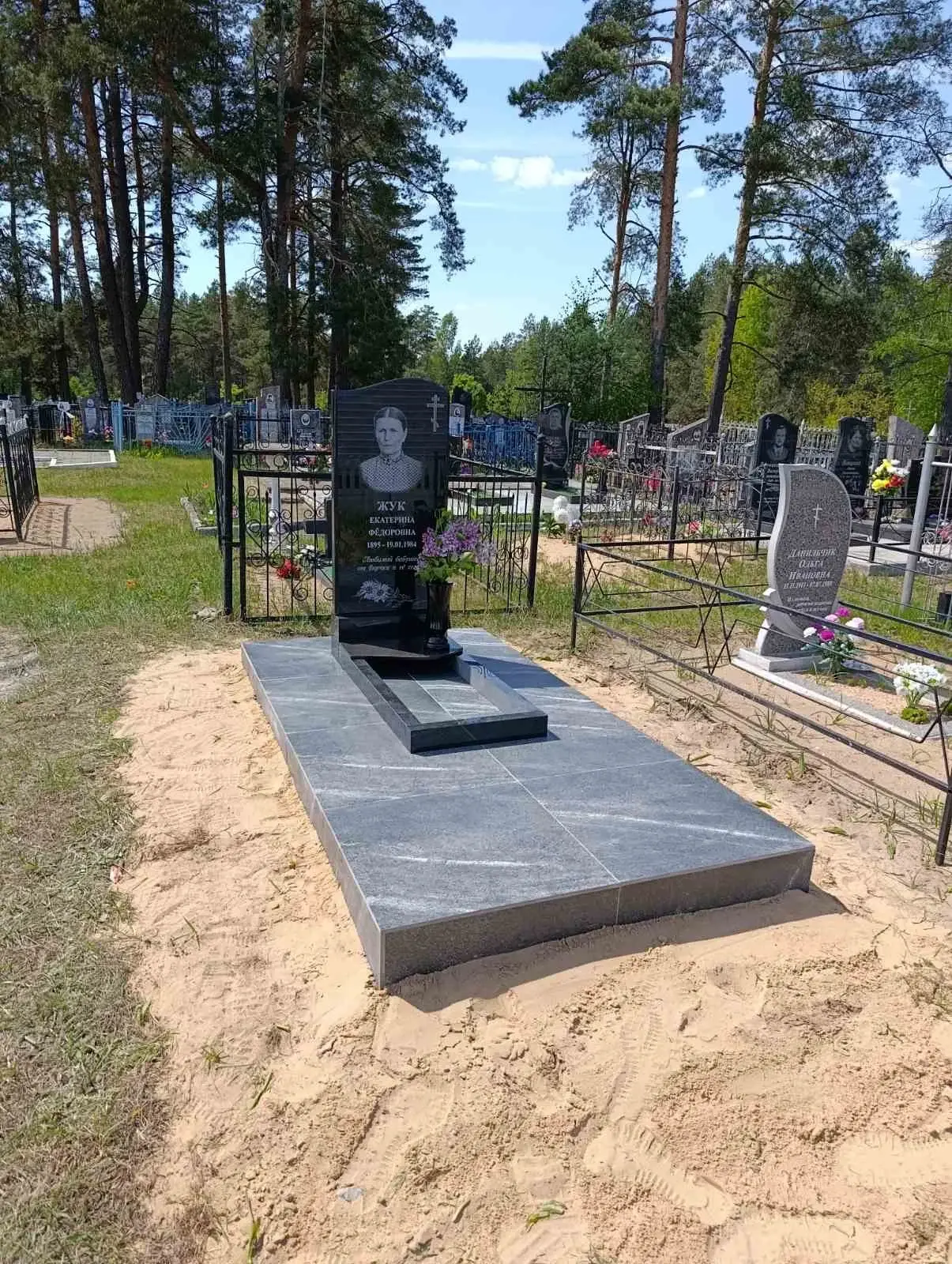 Одиночный памятник с цветником и керамогранитной облицовкой площадки в деревне Углата Брестской области