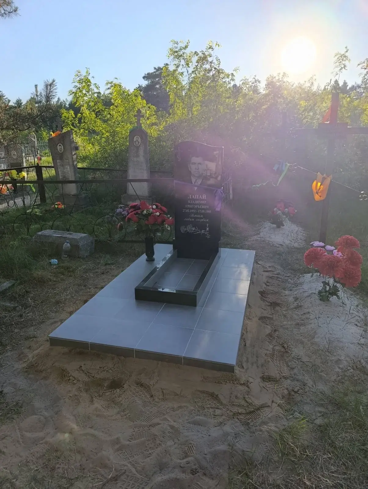 Одиночный памятник с цветником, серой керамогранитной плиткой и вазой в деревне Закозель Брестской области