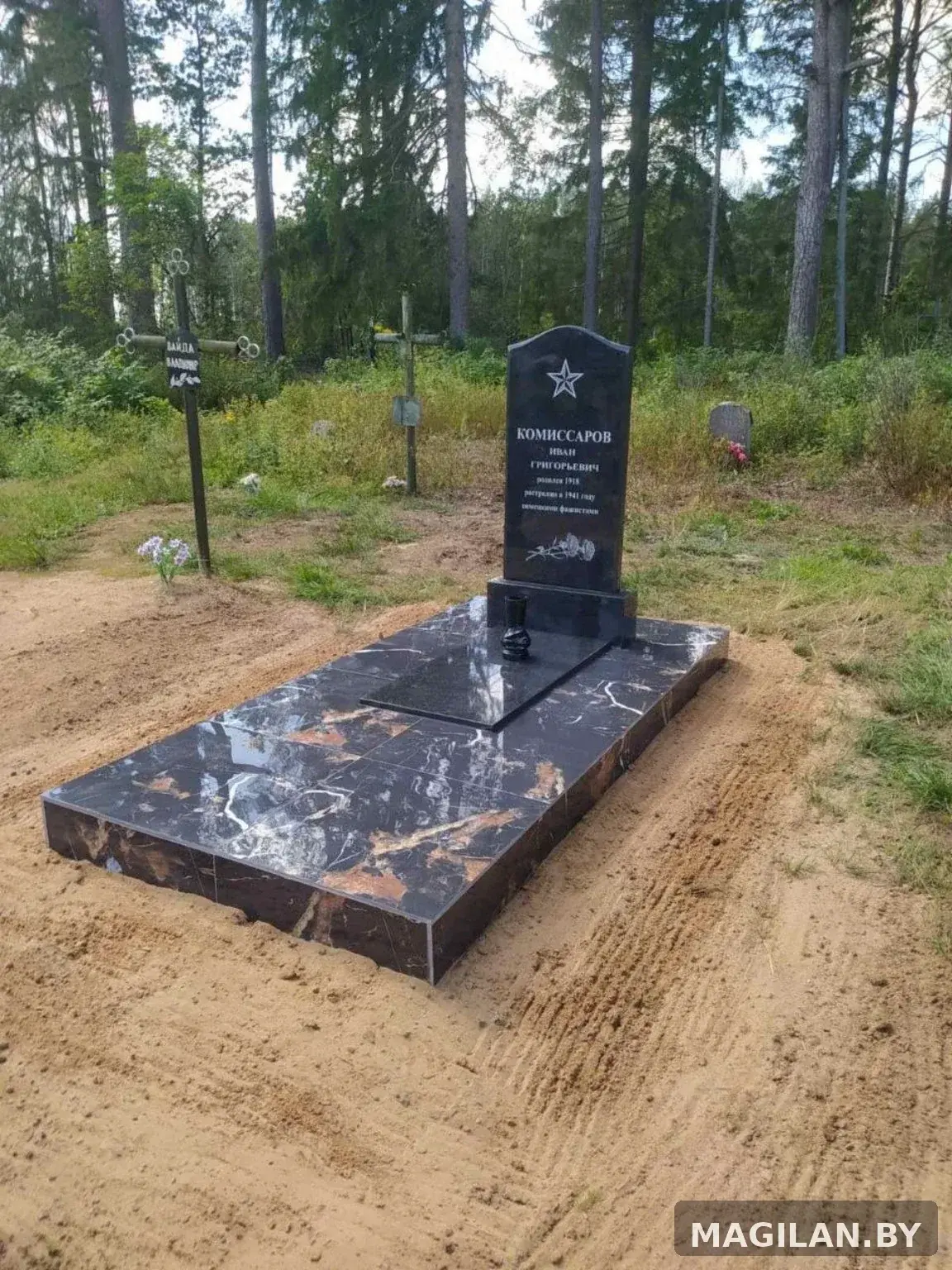Памятник, тёмная плиточная площадка и металлические ригели в Логойском районе