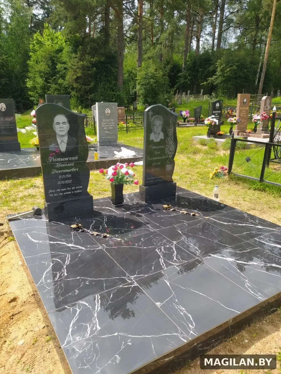 Два памятника на общей тёмной плиточной площадке в Минской области