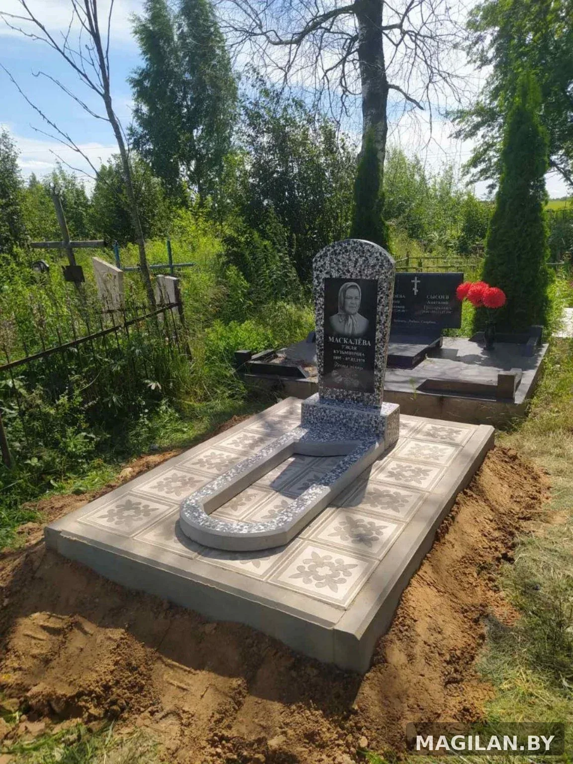 Памятник с цветником и светлым плиточным благоустройством в деревне Холопеничи Крупского района