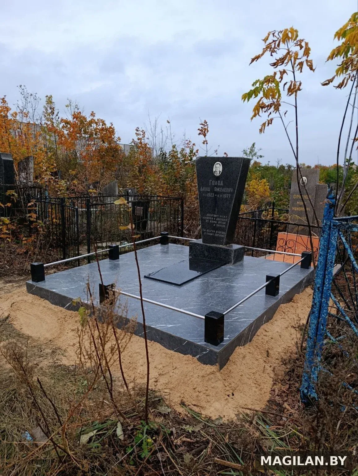 Памятник на серой плиточной площадке с металлическими ригелями в Калинковичах
