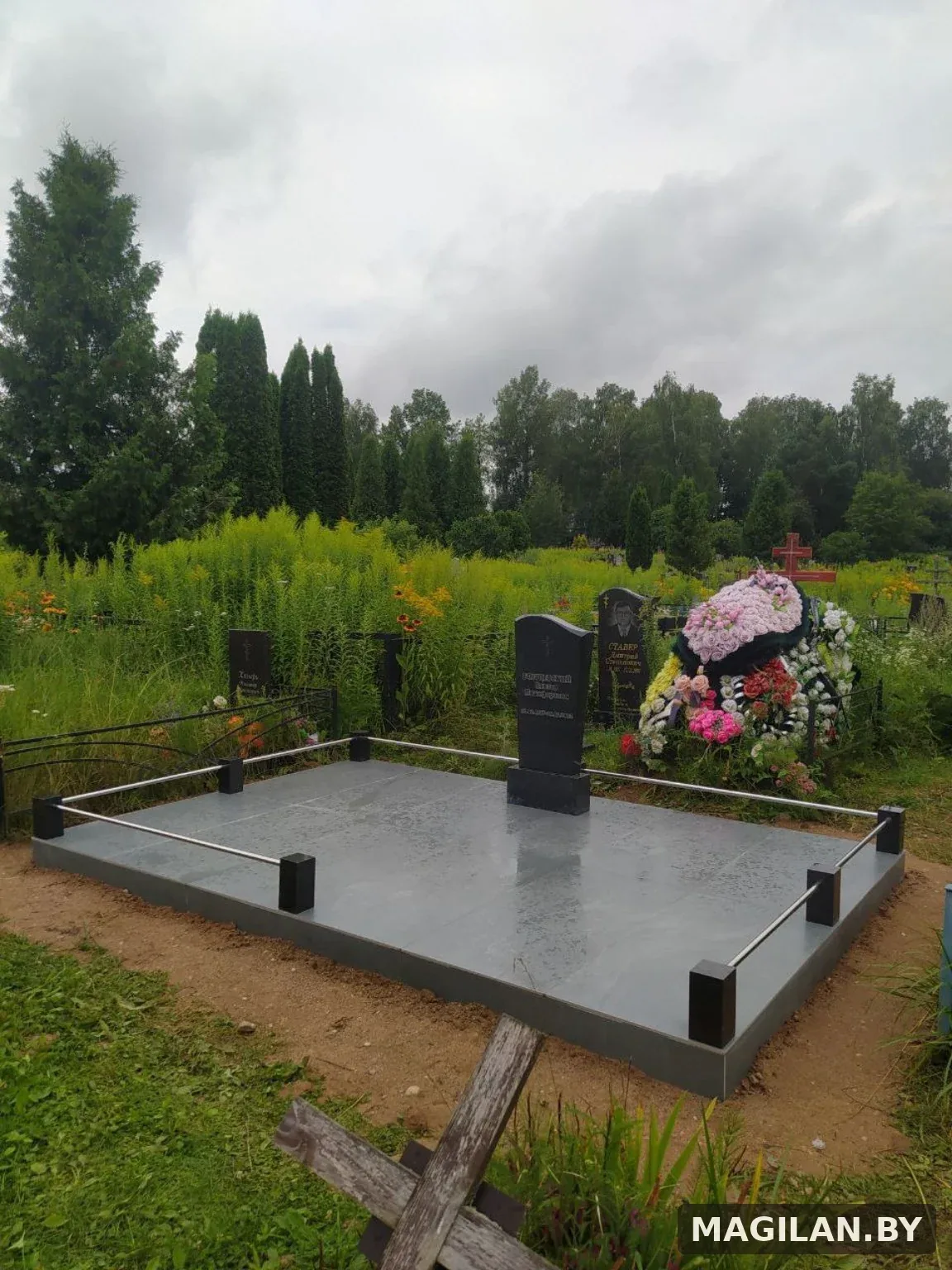 Два памятника на общей тёмной плиточной площадке с металлическими ригелями в Боровлянах под Минском