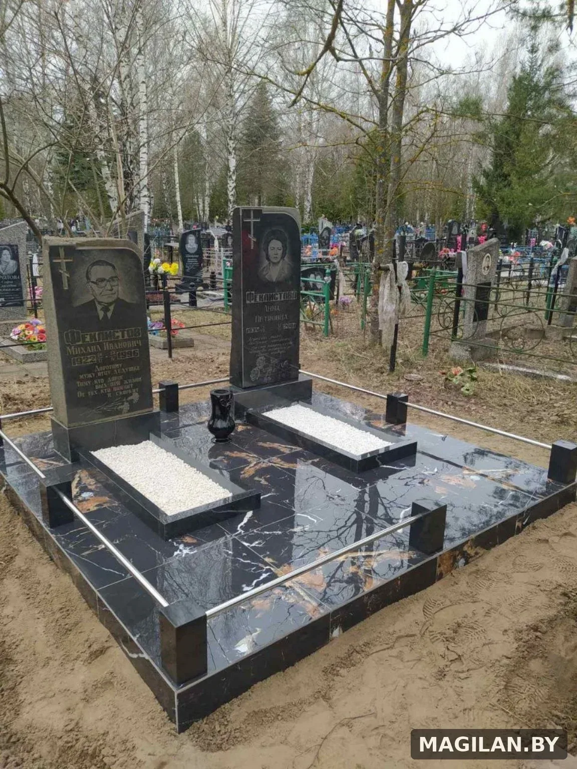 Два памятника на тёмной плиточной площадке с металлическими ригелями в Жлобине